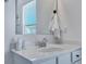 Bright bathroom featuring white vanity, mirror, and chrome fixtures with a view through the window at 107 Willett Ln, Summerville, SC 29486