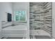 Bathroom with tiled walls, soaking tub, glass shower, and gray rug at 107 Willett Ln, Summerville, SC 29486