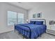 Bright bedroom featuring blue bedding, side tables, and a view through the window at 107 Willett Ln, Summerville, SC 29486