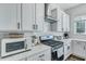 Bright kitchen showcasing white cabinets, modern appliances, and a sleek stainless steel range hood at 107 Willett Ln, Summerville, SC 29486