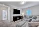 Comfortable living room featuring a plush gray sectional sofa, patterned ottoman, and large screen TV at 107 Willett Ln, Summerville, SC 29486