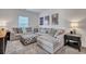 Spacious living room featuring a plush gray sectional sofa with decorative pillows and stylish wall art at 107 Willett Ln, Summerville, SC 29486