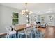 Open-concept dining room features a wooden table, modern chandelier, and access to the living room and outdoor space at 108 Rose Ln, Mount Pleasant, SC 29464
