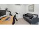 Cozy home office featuring a comfortable grey sofa, desk, and mounted exercise bike for wellness at 108 Rose Ln, Mount Pleasant, SC 29464