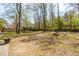 Large backyard featuring a trampoline, outdoor seating, and mature trees providing ample shade at 109 Buckingham Ave, Summerville, SC 29485
