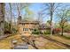 Aerial view of a house with a backyard including a firepit, seating, and mature trees at 109 Buckingham Ave, Summerville, SC 29485