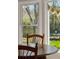 Close-up of a wooden table and chairs in a sunlit breakfast nook with a view to the backyard at 109 Buckingham Ave, Summerville, SC 29485