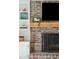 Close-up of the brick fireplace with a decorative screen and built-in shelving in the living room at 109 Buckingham Ave, Summerville, SC 29485