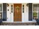 Inviting front entrance featuring a wood door, stylish lanterns, and decorative floral arrangement at 109 Buckingham Ave, Summerville, SC 29485