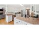 Well-lit kitchen with granite counters, stainless steel appliances, white cabinets, and hardwood floors at 109 Buckingham Ave, Summerville, SC 29485