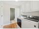 Clean laundry room with modern washer and dryer, white cabinets, and hardwood floors at 109 Buckingham Ave, Summerville, SC 29485