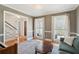 Inviting living room featuring hardwood floors, area rug, and abundant natural light from two large windows at 109 Buckingham Ave, Summerville, SC 29485