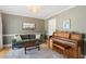 Cozy living room with a green sofa, piano, hardwood floors, and neutral colored walls at 109 Buckingham Ave, Summerville, SC 29485