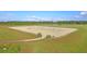 Outdoor horse riding arena with well-maintained sand surface and surrounding green fields, ideal for equestrian activities at 111 Peninsula Dr, Ravenel, SC 29470