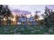 Modern farmhouse exterior with beautiful landscaping, surrounded by trees and a stunning sunset at 111 Peninsula Dr, Ravenel, SC 29470