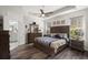 Well-lit primary bedroom boasts a tray ceiling, en-suite bathroom, and wood-look flooring at 1174 Old Field Dr, Summerville, SC 29483