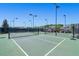 Multiple tennis courts with green surfaces and lighting surrounded by fencing and greenery at 1174 Old Field Dr, Summerville, SC 29483