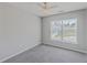 Bright bedroom featuring plush carpet, a modern ceiling fan, and natural light from the large window at 118 Lamplighter Ln, Summerville, SC 29486