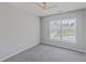 Bright bedroom featuring plush carpet, a modern ceiling fan, and natural light from the large window at 118 Lamplighter Ln, Summerville, SC 29486