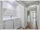 Well-lit laundry room with white washer and dryer and views of the upstairs hallway at 118 Lamplighter Ln, Summerville, SC 29486
