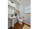 A half bathroom showcasing a pedestal sink, wood floors, and a wall-mounted wooden shelf at 1309 Belgian Draft Dr, Mount Pleasant, SC 29466