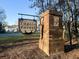 A brick sign for Tupelo Forest with a hanging decorative wooden sign and landscaping at 1309 Belgian Draft Dr, Mount Pleasant, SC 29466