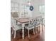 Dining area with a rustic wood table and white chairs near large windows with natural light at 1309 Belgian Draft Dr, Mount Pleasant, SC 29466