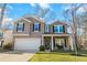 Inviting two-story home with a two-car garage, classic black shutters, and a cozy covered front porch at 1309 Belgian Draft Dr, Mount Pleasant, SC 29466