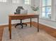 Detailed view of a home office featuring a wooden desk, ergonomic chair, and plenty of natural light at 1309 Belgian Draft Dr, Mount Pleasant, SC 29466