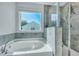 Bathroom featuring a soaking tub, walk-in shower with tiled walls, and a bright window at 131 Swaying Palm Dr, Summerville, SC 29485