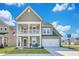 Charming two-story home featuring a welcoming front porch, attached garage, and well-manicured lawn at 131 Swaying Palm Dr, Summerville, SC 29485