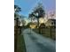Gated driveway leading to a well-lit garage in a serene, fenced yard at twilight at 146 Picard Dr, Ladson, SC 29456