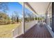 Cozy front porch featuring a wooden deck, white railing, and serene views of the surrounding landscape at 146 Picard Dr, Ladson, SC 29456