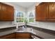 Well lit kitchen sink with wood cabinets, stainless steel sink, and window views at 146 Picard Dr, Ladson, SC 29456