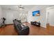 Comfortable living room with a leather sofa, large windows, television, and view of the connected outdoor space at 146 Picard Dr, Ladson, SC 29456