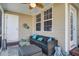 Inviting screened porch with a comfortable wicker sofa, ottoman, and ceiling fan at 156 Woodward Rd, Goose Creek, SC 29445