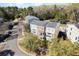 Beautiful aerial view of a multi-story home with manicured landscaping and a serene pond in a lush, wooded neighborhood at 1587 Bluewater Way, Charleston, SC 29414