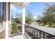 A bright balcony view featuring black railings, natural light, and mature trees overlooking the neighborhood at 1587 Bluewater Way, Charleston, SC 29414