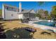 Inviting backyard with a pool, cornhole, lush lawn, and a screened-in porch at 171 Cartright St, Charleston, SC 29492
