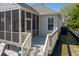 Backyard view of screened porch, white siding, lush landscaping, and deck access at 171 Cartright St, Charleston, SC 29492