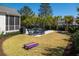 Green backyard with a patio, outdoor seating, and cornhole boards for entertainment at 171 Cartright St, Charleston, SC 29492