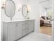 Modern bathroom with dual sinks, gray cabinetry, marble floors, and decorative lighting at 171 Cartright St, Charleston, SC 29492