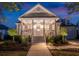 Inviting home exterior at twilight, showcasing a covered porch and manicured landscaping at 171 Cartright St, Charleston, SC 29492