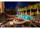 Entertaining backyard with a firepit and pool is surrounded by tall palm trees and mature shrubbery at 171 Cartright St, Charleston, SC 29492