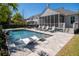 Sparkling pool with lounge chairs surrounded by lush landscaping and a screened porch at 171 Cartright St, Charleston, SC 29492