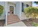 Close-up of the front door with brick steps and lush landscaping, creating an inviting entrance at 1896 Palmetto Isle Dr, Mount Pleasant, SC 29466