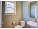 Bright bathroom with a window, toilet, and sink. The walls are painted in a soothing green color at 1926 Grimball Rd, Charleston, SC 29412