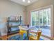 Cozy dining area with a round table, yellow chairs, and a sliding door to the outdoors at 1926 Grimball Rd, Charleston, SC 29412