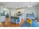 Open kitchen with island, white cabinets, granite counters, stainless appliances and eat-in area with slider to outside at 1926 Grimball Rd, Charleston, SC 29412
