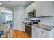 Modern kitchen featuring stainless steel appliances, white cabinets, and granite countertops, connecting to the dining area at 1926 Grimball Rd, Charleston, SC 29412